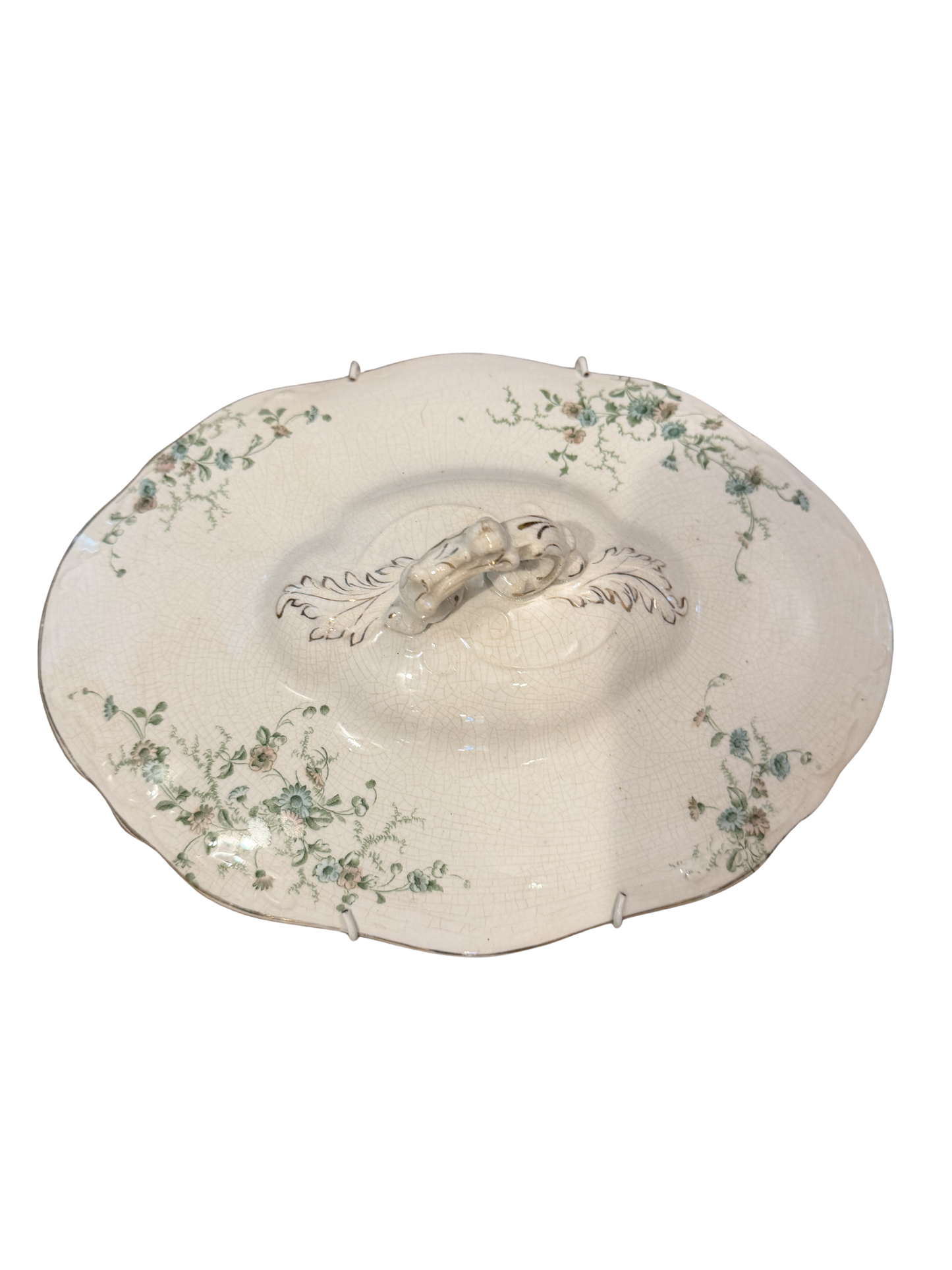 Antique ivory porcelain tureen lid with trailing green floral sprays, scalloped edge, tab handles, and acanthus scroll finial