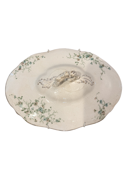 Antique ivory porcelain tureen lid with trailing green floral sprays, scalloped edge, tab handles, and acanthus scroll finial